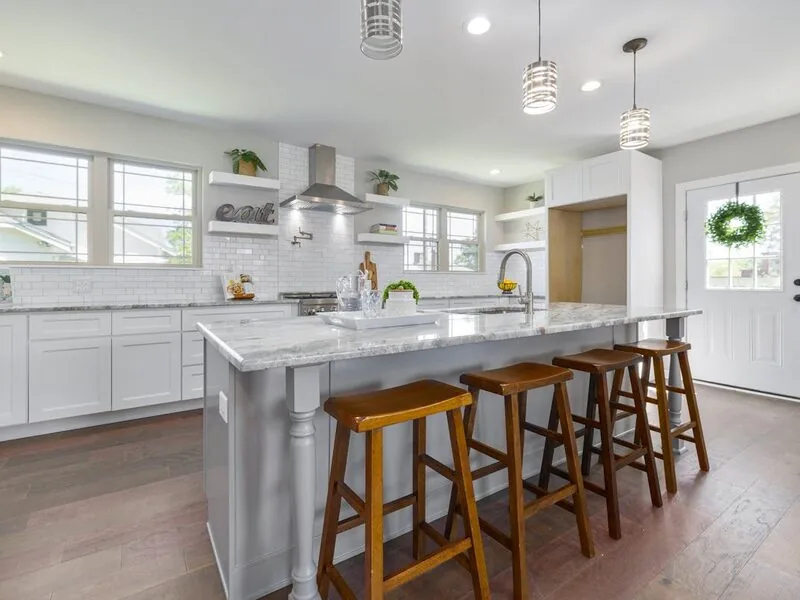 Bright modern kitchen with large island and bar stools, Apex before and after remodel by Ridgeway
